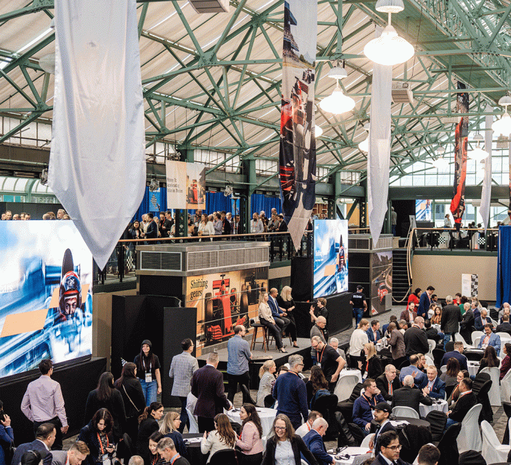 A group of delegates meeting at a Formula 1 themed event at the Crystal Garden, part of the Victoria Conference Centre, in Victoria, BC