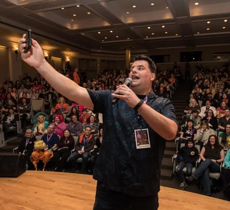 A performer takes a selfie on stage at Capital City Comic Con