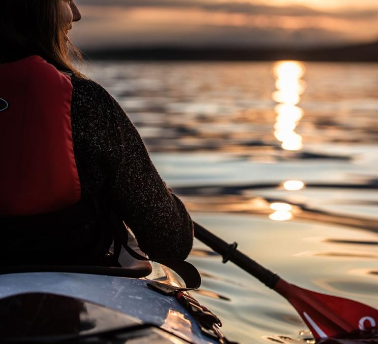 A woman paddles through the Salish Sea off the coast of Victoria, BC