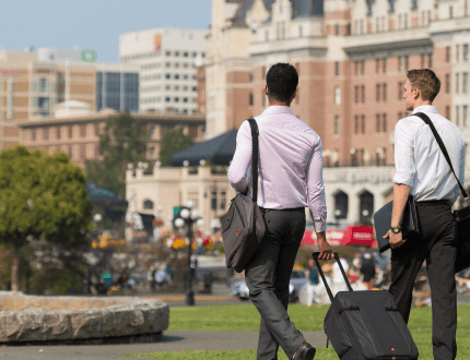 two peopla walking outside with luggage