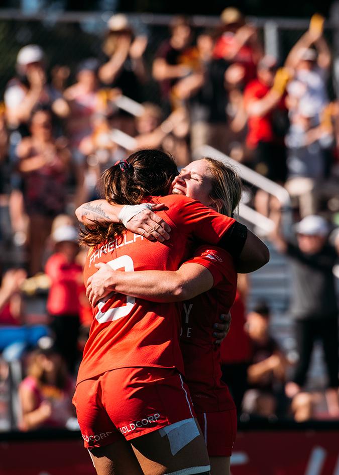 Two players from Canada's Women's Sevens rugby team celebrate after scoring in Victoria, BC