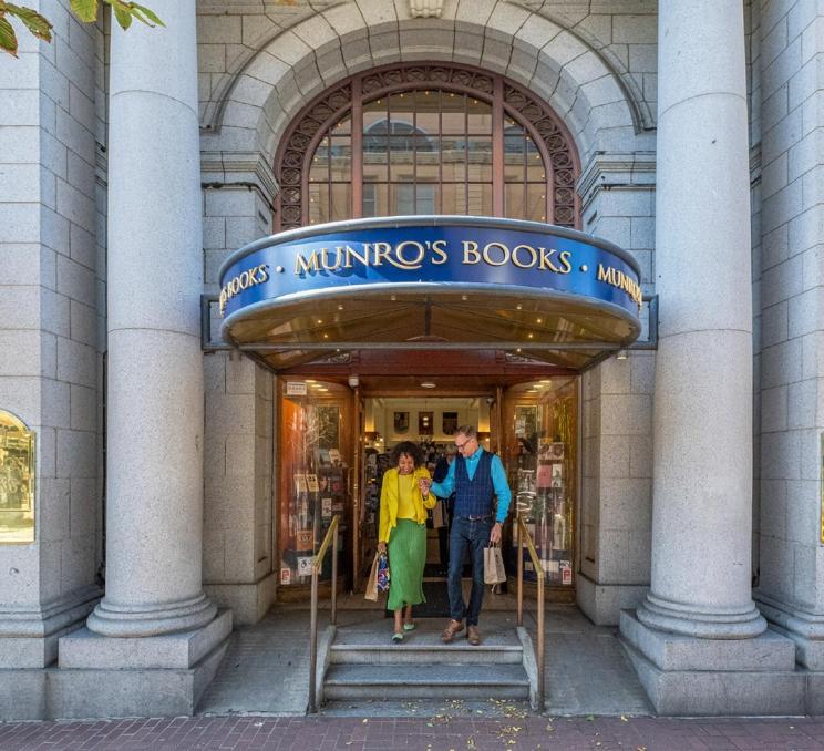 A couple walks out the front door of Munro's Books, a bookstore located in a heritage building in Victoria, BC