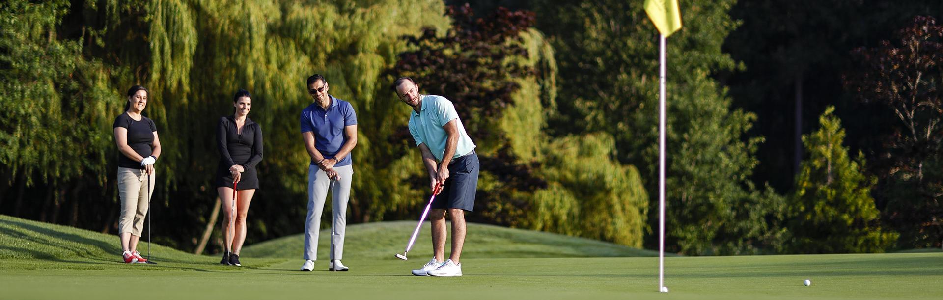 A group of colleagues putting on the green at a golf course in Victoria, BC