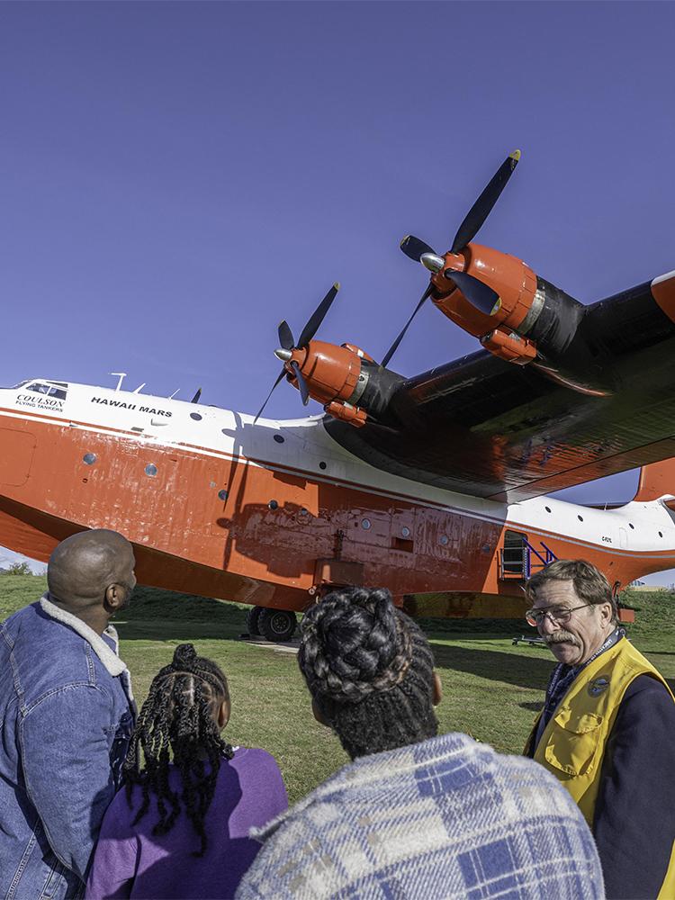 A guide shows a family the Hawaii Mars, a red and white water bomber, at the BC Aviation Museum in Victoria, BC
