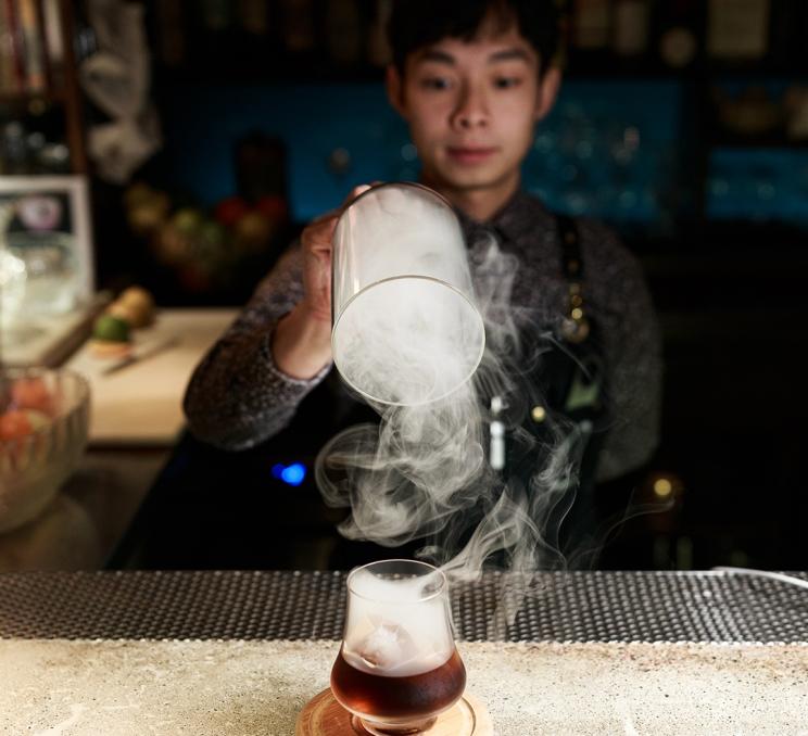 A bartender presents a smokey whiskey cocktail at Clive's Classic Lounge in Victoria, BC
