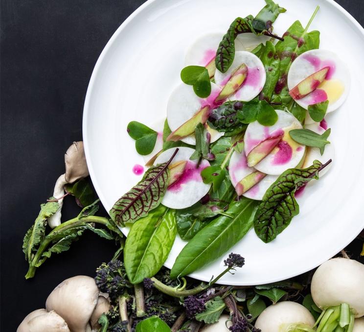 A salad presented on a white plate at The Courtney Room in Victoria, BC