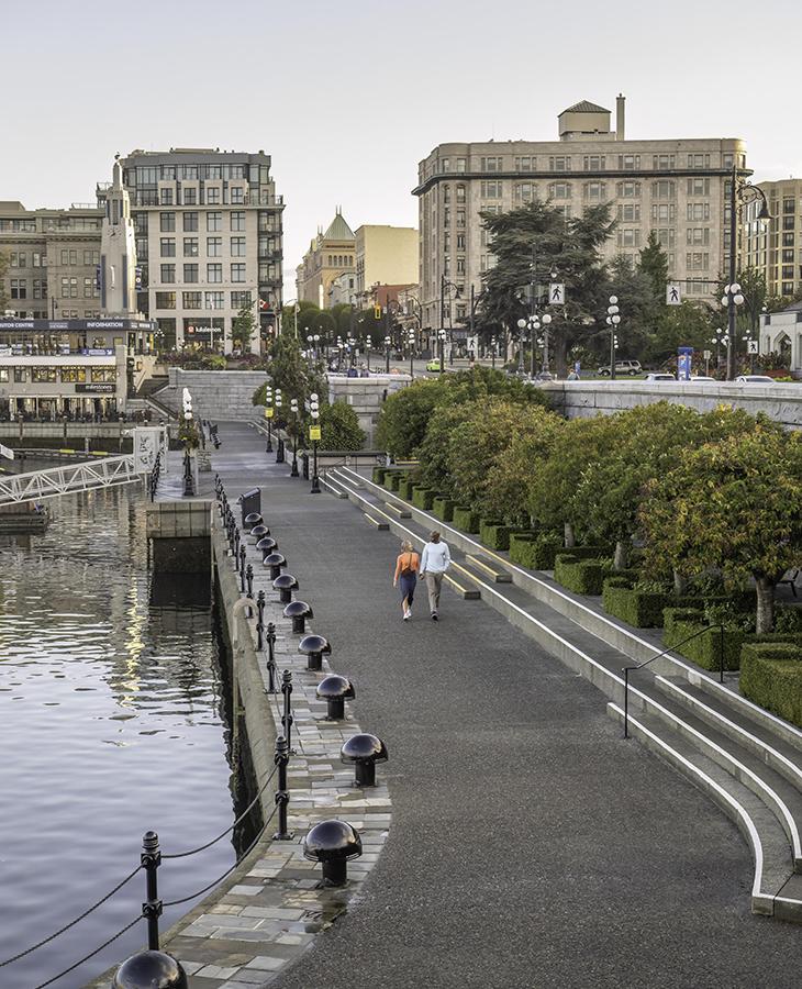 A couple walks along the lower causeway of the Inner Harbour in downtown Victoria, BC