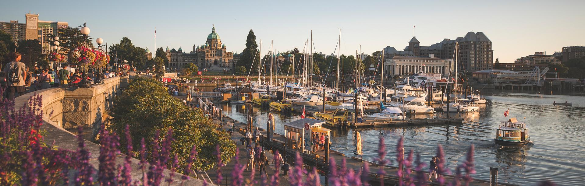 A view of the BC Parliament Buildings across the Inner Harbour as a Harbour Ferry taxis across the water in Victoria, BC