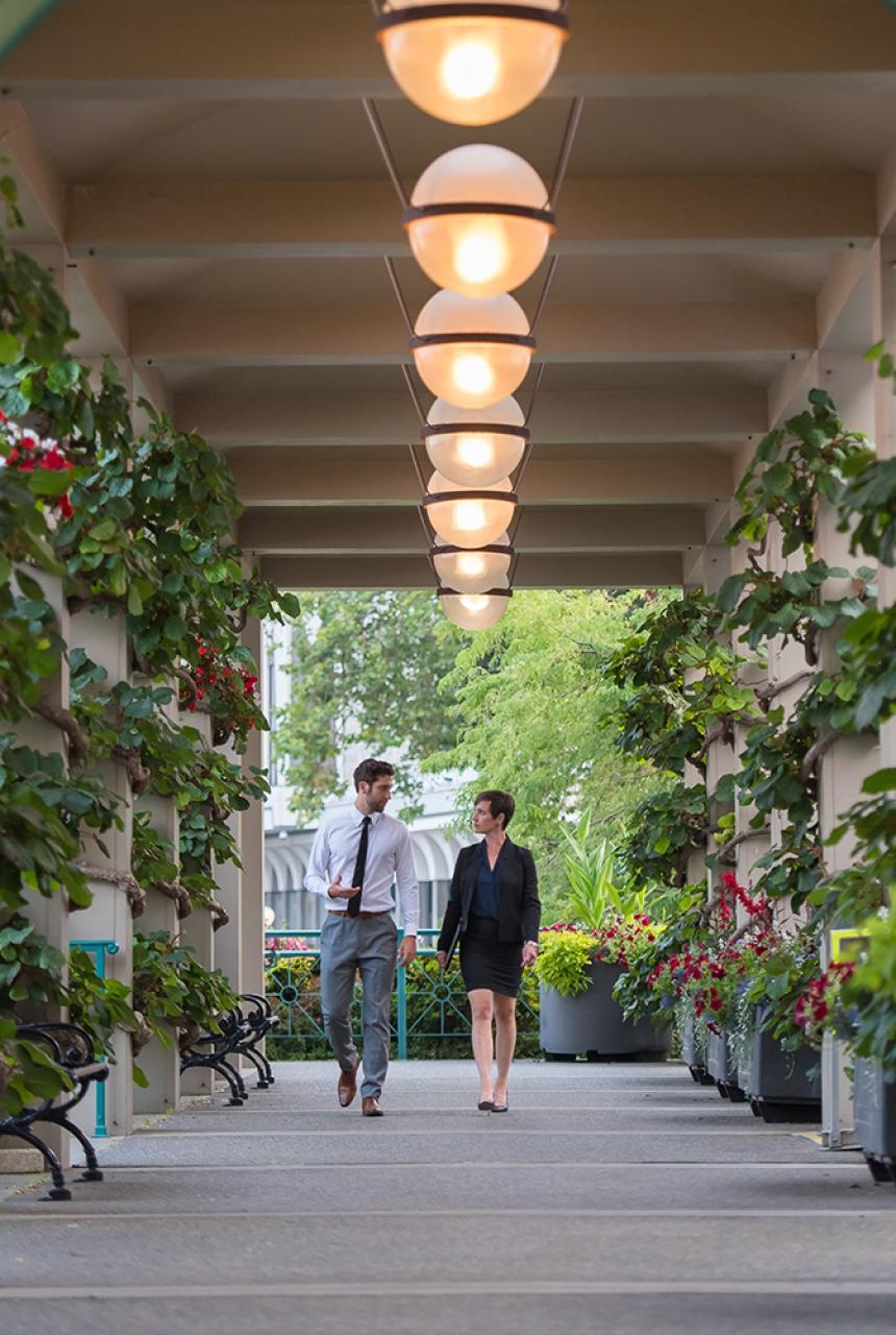 Two delegates walk through an outdoor hallway at the Victoria Conference Centre in Victoria, BC