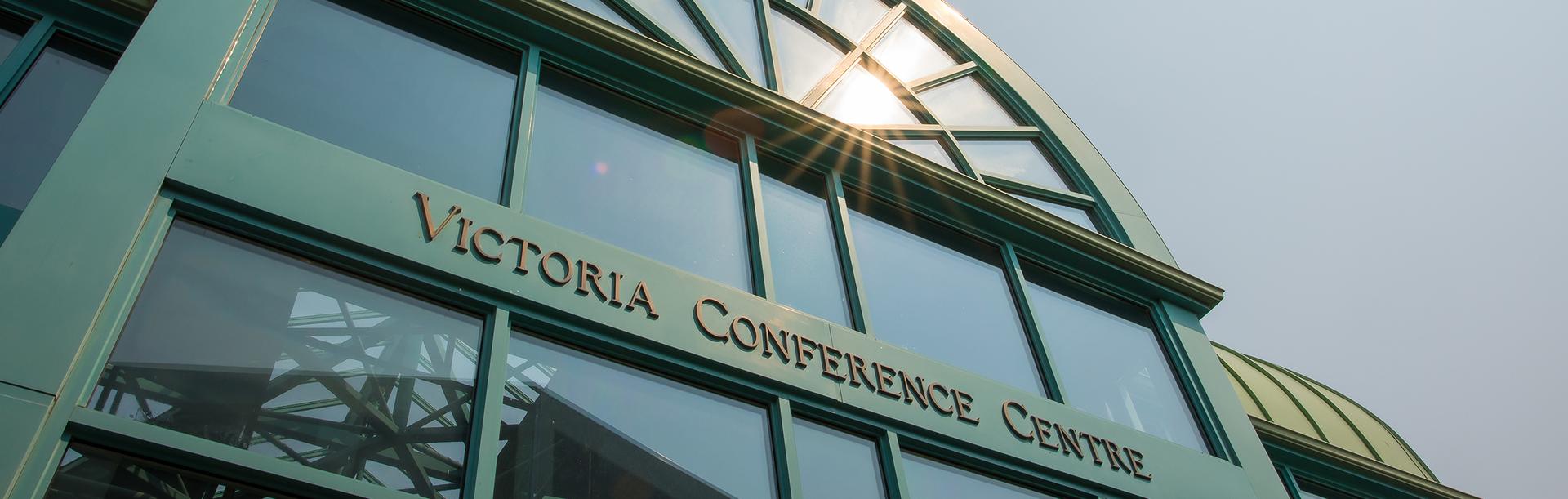 Sunshine glistens off the glass of the entrance way of the Victoria Conference Centre in Victoria, BC