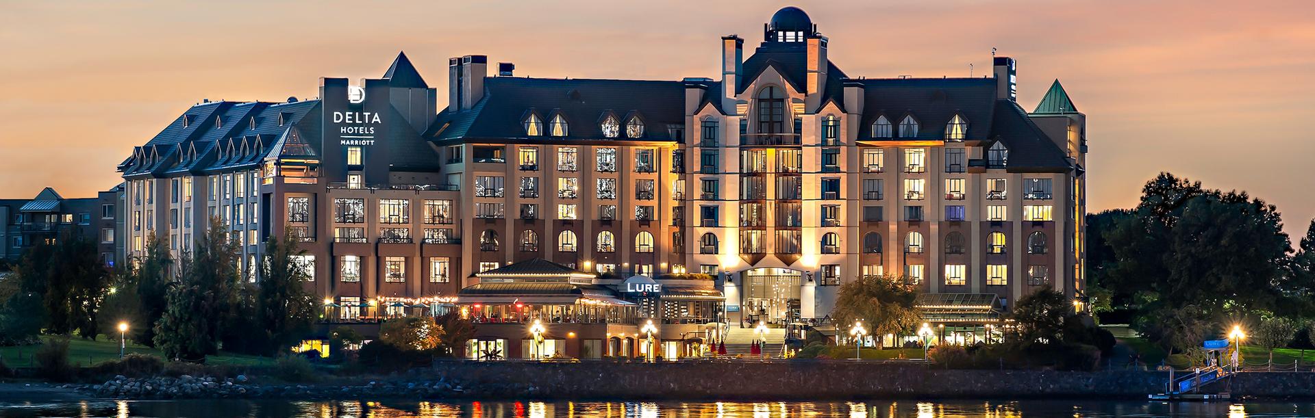 The Delta Hotels by Marriott Victoria Ocean Point Resort at sunset on Victoria, BC's Inner Harbour