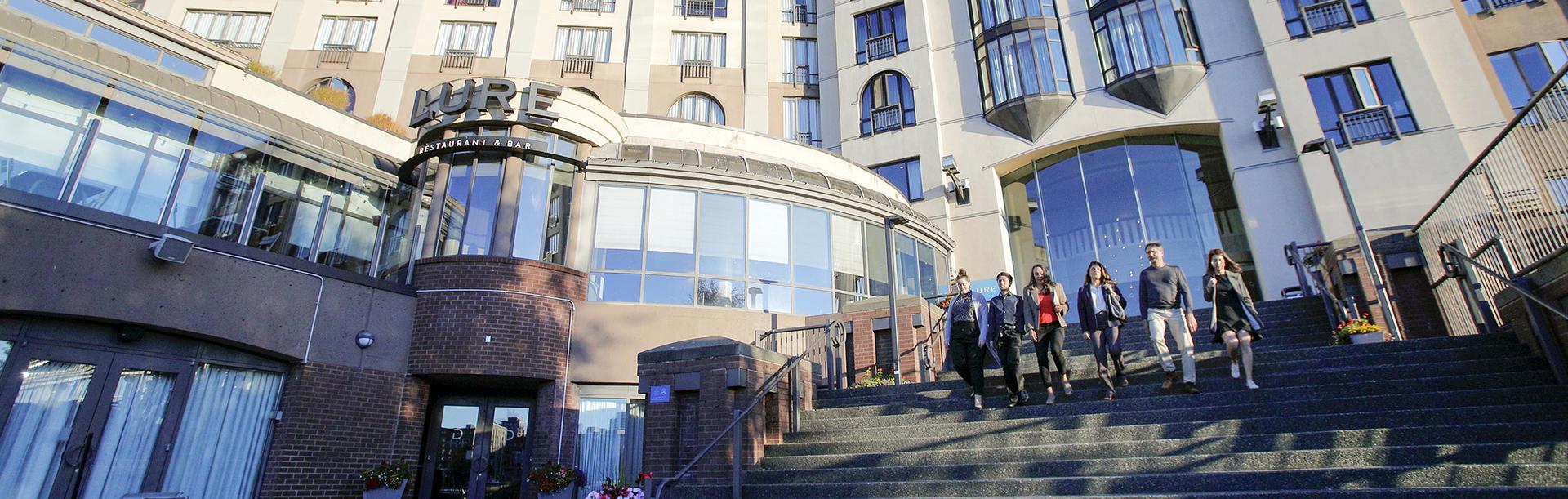 A group of delegates exit the Delta Hotels by Marriott Ocean Point Resort and walk down the staircase toward the Inner Harbour in Victoria, BC