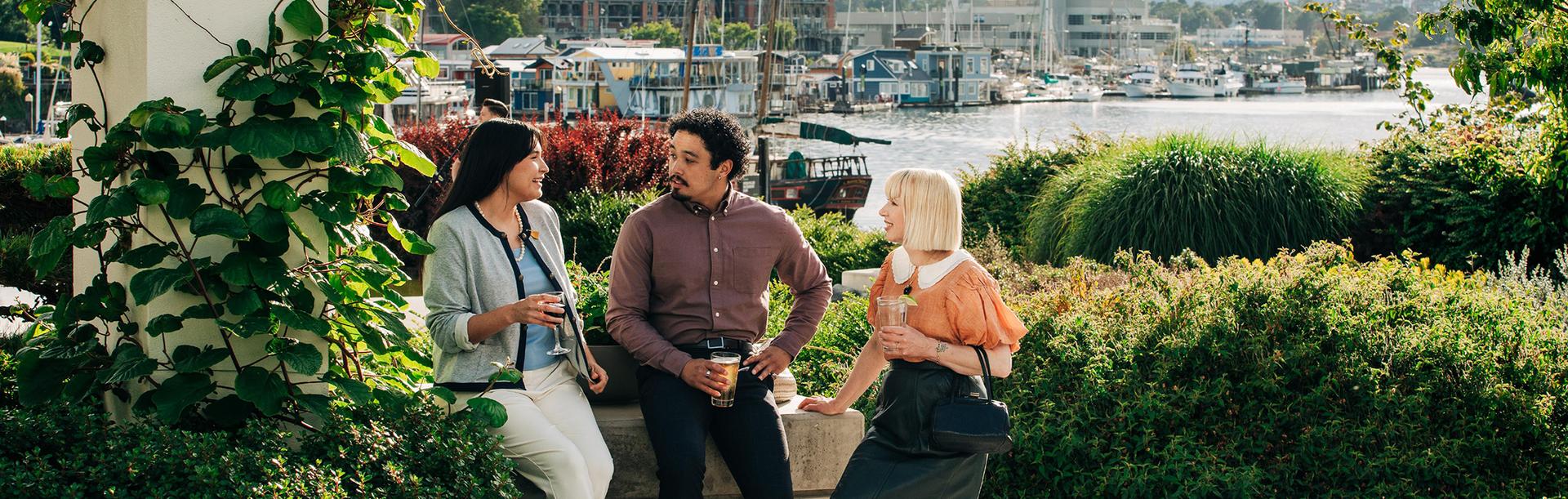 Three delegates meet over drinks in the garden at the Inn at Laurel Point on Victoria, BC's Inner Harbour