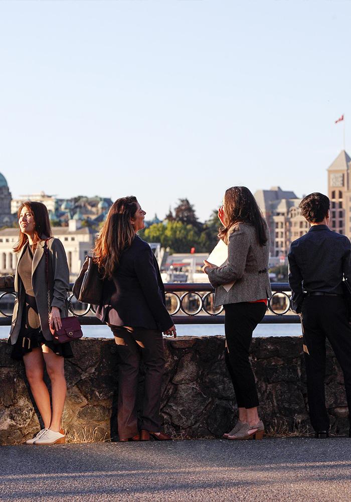Delegates discuss business while looking out at the Inner Harbour of Victoria, BC
