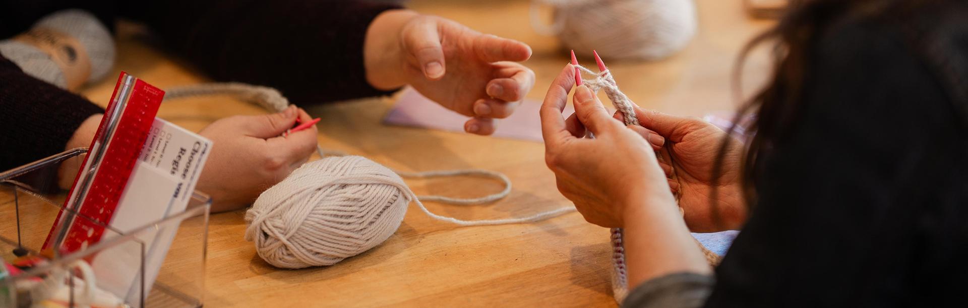 A group of people work on knitting during a workshop at Beehive Wool Shop in Victoria, BC