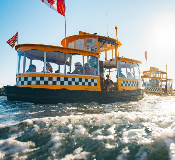 A group of delegates commute across the Inner Harbour aboard a Victoria Harbour Ferries vessel in Victoria, BC