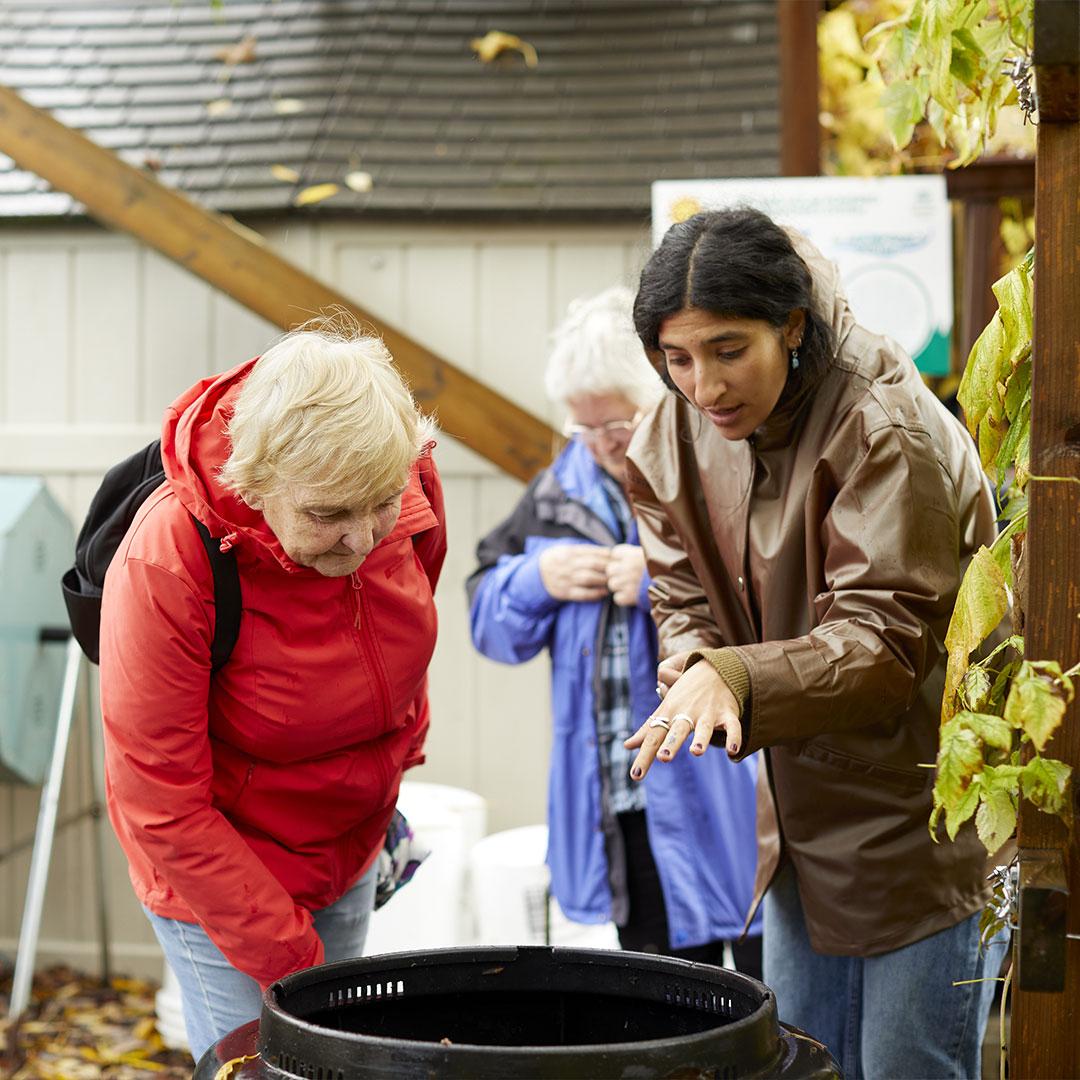An instructor from the Compost Education Centre shows a learner about composting in Victoria, BC