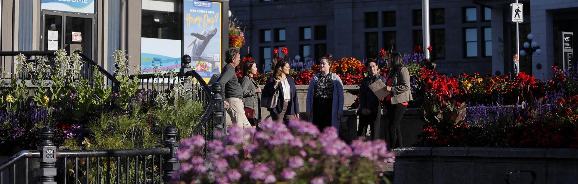 A group of professionals meet outside of the Victoria Visitor Centre in Victoria, BC