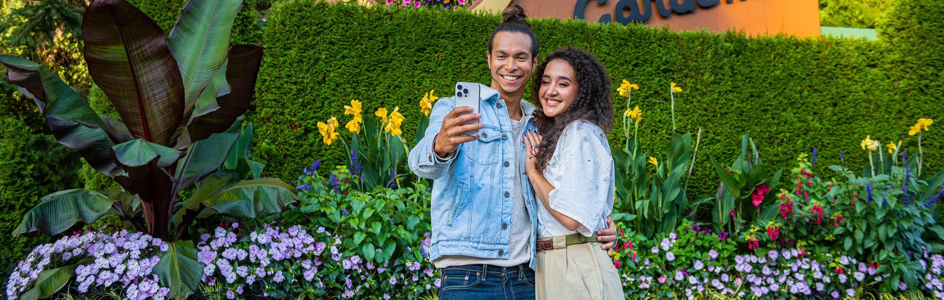 A young couple takes a selfie at The Butchart Gardens in Victoria, BC
