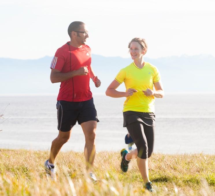 A pair of runners follow the path along Dallas Road in Victoria, BC