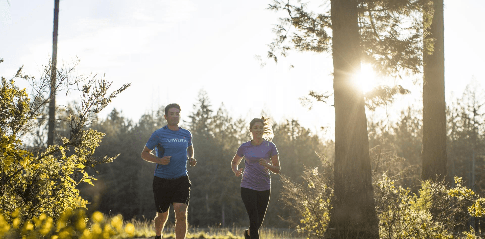 two people running in the woods