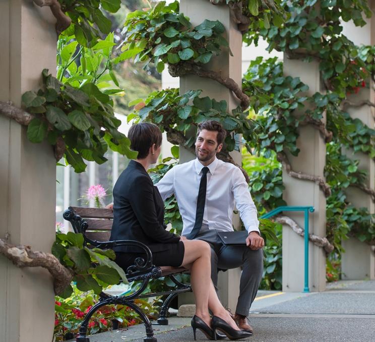 A pair of people meet outside the Victoria Conference Centre in Victoria, BC